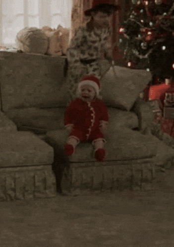 a young boy is sitting on a couch next to a stuffed monkey .