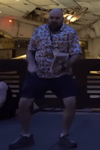 a man with a beard is dancing in a room