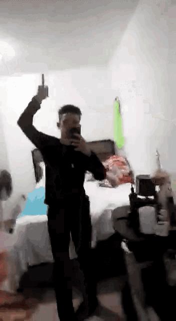 a man is taking a picture of himself in a bedroom while giving the middle finger
