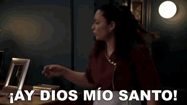 a woman is talking on a cell phone and saying " ay dios mio santo "