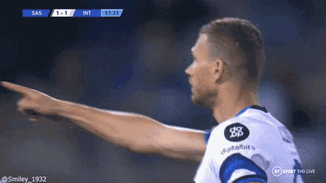 a soccer player is pointing at the scoreboard which says sas 1-1