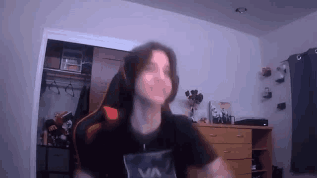 a man is sitting in a gaming chair in a bedroom .