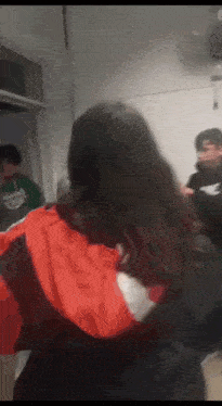 a group of people are standing in a room with one wearing a nike shirt