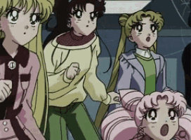 a group of anime girls are standing next to each other and one of them is wearing a sweater with the letter e on it