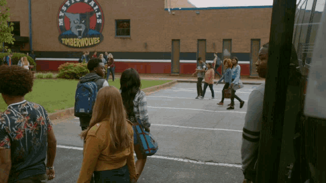 a group of people walking in front of a building that says timberwolves on it