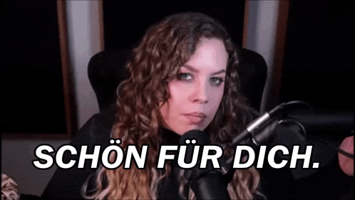 a woman with curly hair is sitting in front of a microphone and says , `` schön für dich '' .