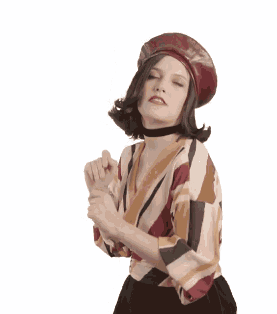 a woman wearing a beret and a striped shirt is holding her hands together .