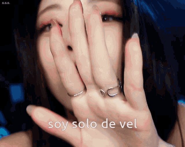 a woman covering her face with her hands and the words soy solo de vel written below her