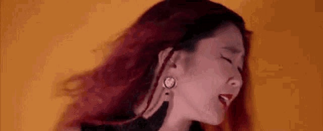a close up of a woman 's face with red hair .