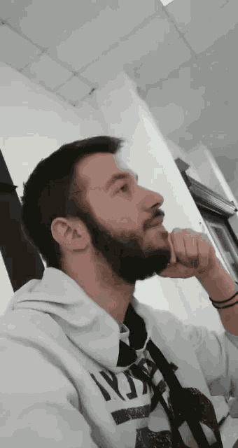 a man with a beard is wearing a white hoodie that says russia on it