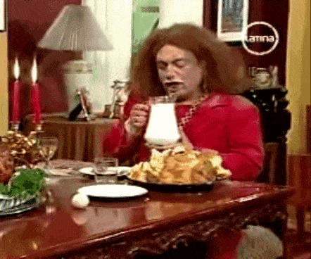 a woman is sitting at a table drinking milk from a pitcher ..
