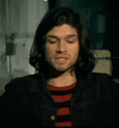 a close up of a man 's face with a red shirt on