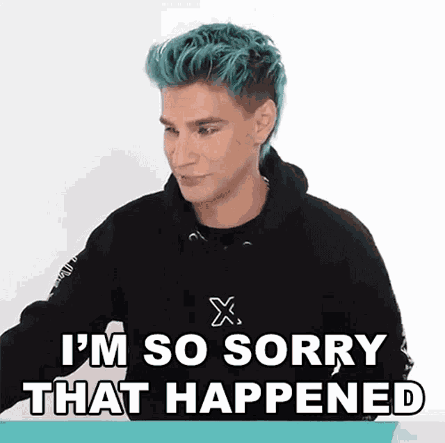 a man with blue hair is sitting at a table and says i 'm so sorry that happened .