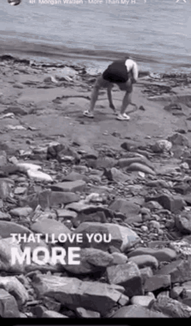 a man is kneeling on a rocky beach with the words that i love you more