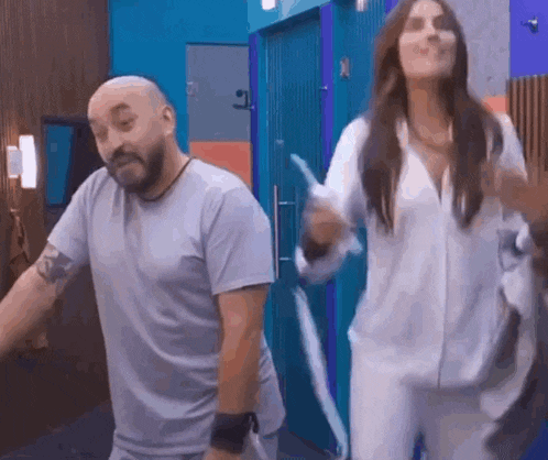 a man and a woman are standing next to each other in a room .