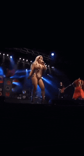 a woman singing into a microphone on stage