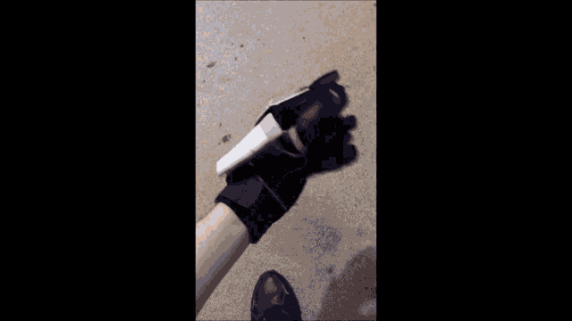 a person is holding a piece of duct tape on a carpeted floor