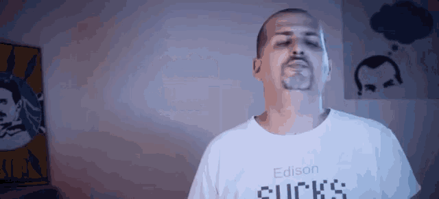 a man wearing a white shirt that says edison sucks on it