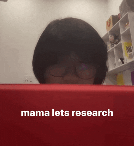 a woman wearing glasses looks at a red box that says mama lets research on it