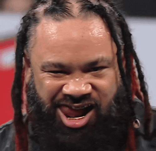 a man with dreadlocks and a beard makes a funny face