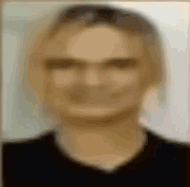 a blurry picture of a man with glasses and a black shirt