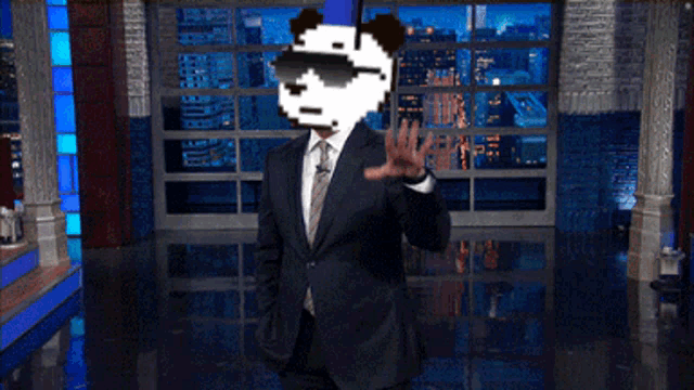 a man in a suit and tie with a pixelated panda on his head waving