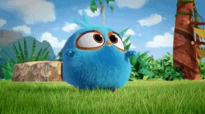 a blue bird with big eyes standing in the grass