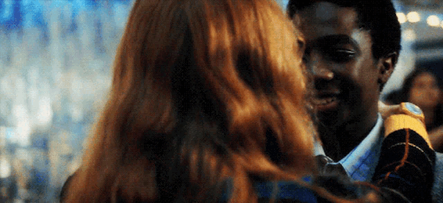 a man and a woman are hugging each other in a room .