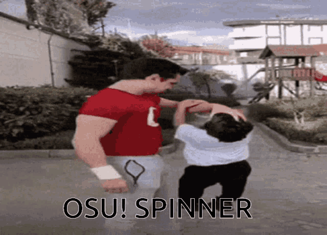 a man in a red shirt with the letter c on it is holding a child in a white shirt with the word osu on it