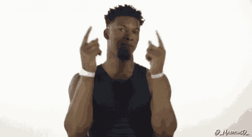 a man in a black tank top is pointing up at something