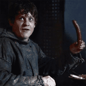 a man in a hooded jacket is holding a sausage