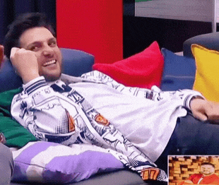 a man laying on a couch with a picture of a man in a red shirt