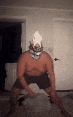 a man without a shirt is wearing a shark mask and glasses