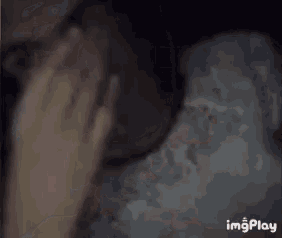 a close up of a person 's face in a dark room with a blurred background .