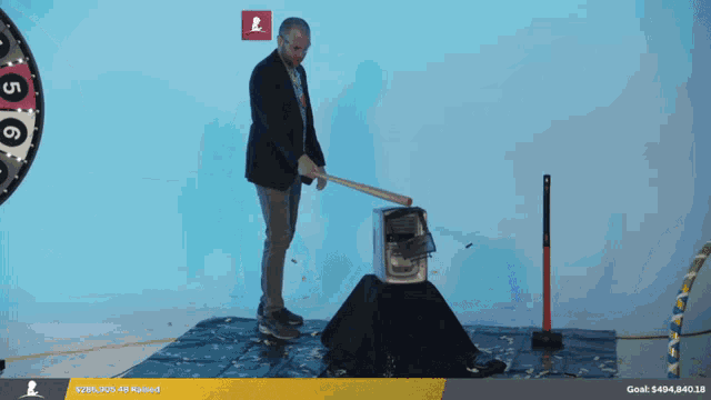 a man is using a hammer to smash a box with a goal of $ 296,905.49