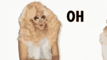 a woman with a wig and glasses is standing next to a sign that says oh my god .