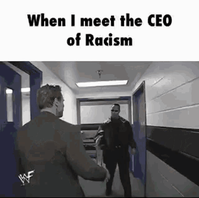 a man in a suit is shaking hands with another man in a hallway in a hallway .