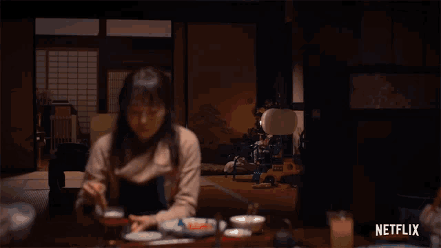 a woman sits at a table with netflix written on the bottom