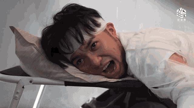 a young man with a bandage on his head is laying on a bed