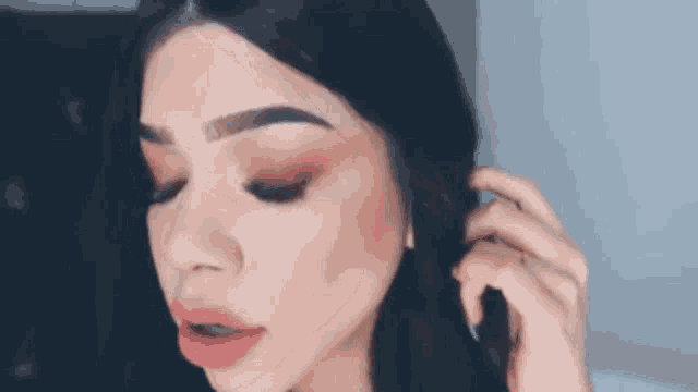 a close up of a woman 's face with makeup on and earrings .