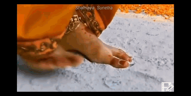 a close up of a woman 's feet on a sandy surface