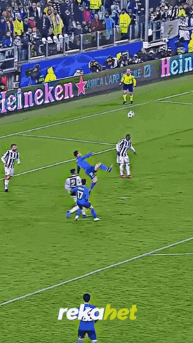 a soccer player is running on a field with a sign that says rekabet on it
