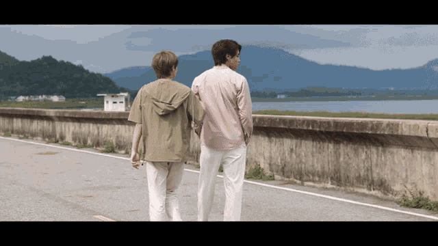 two people walking along a road holding hands