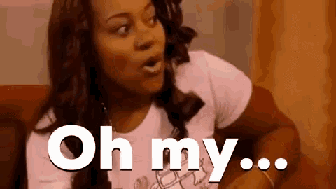 a woman in a pink shirt is sitting on a red couch and saying oh my ...