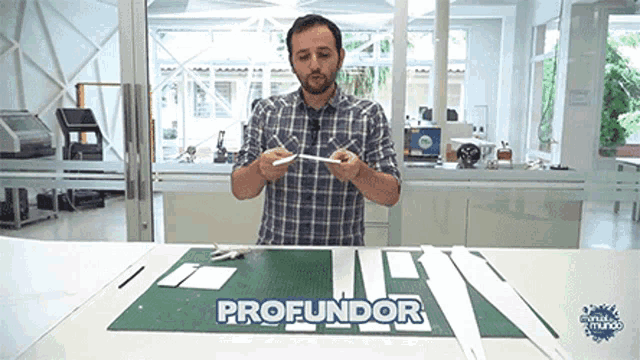 a man in a plaid shirt is standing in front of a table with the word profundor written on it