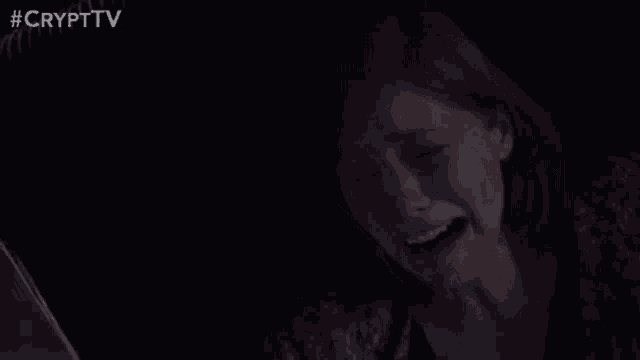 a close up of a woman 's face in a dark room with her eyes closed .