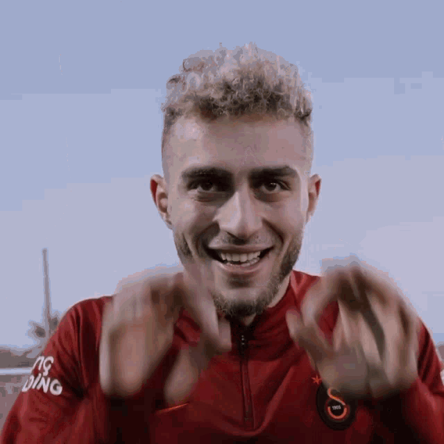 a man wearing a red shirt with the letter s on the sleeve