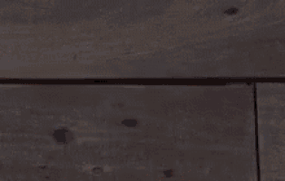 a close up of a person 's hand reaching out towards a wall .