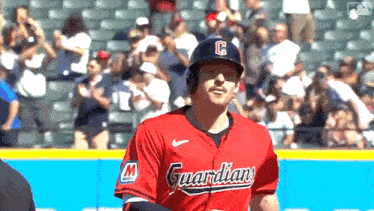 a baseball player is wearing a red jersey with the word guardians on it