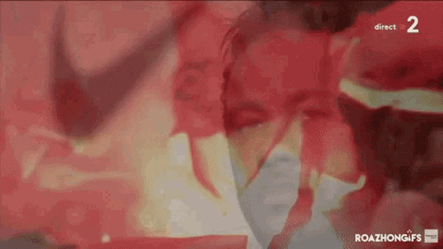 a blurred image of a man 's face with the number 2 on the bottom right